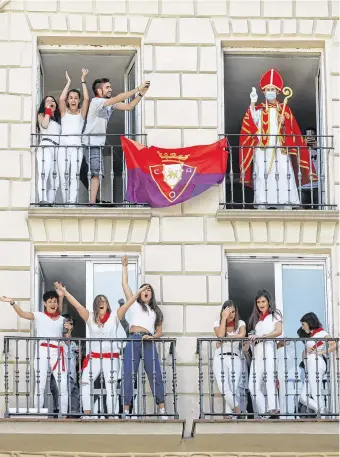  ??  ?? Apparition: A reveller dressed up as Saint Fermin waves from a balcony in front of the town hall in Pamplona, Spain. The San Fermin Festival has been cancelled due to Covid-19