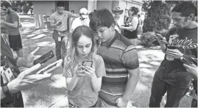  ??  ?? Pokémon GO! players Thompson Childress, 11, right, and Alex Landrigan, 11, collect a pocket monster during a raid at Levitt Shell on July 5. The virtual game that swept the world two years ago is still going strong. MARK WEBER/THE COMMERCIAL APPEAL