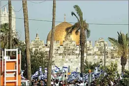  ?? ARIEL SCHALIT / AP ?? Israelis wave national flags in front of Damascus Gate outside Jerusalem’s Old City to mark Jerusalem Day, an Israeli holiday celebratin­g the capture of the Old City during the 1967 Mideast war on Sunday.