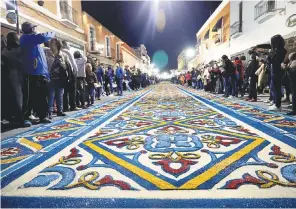  ??  ?? “Nadie duerme”. Cientos de personas observan los coloridos tapetes hechos con aserrín en Huamantla, Tlaxcala, durante un popular festejo en honor a la Virgen de la Caridad.