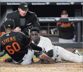  ?? Julie Jacobson ?? The Associated Press Umpire Ed Hickox prepares to call out Didi Gregorius, who tried scoring from third base on an errant pitch by Orioles reliever Mychal Givens in the 11th inning of the Yankees’ 7-3, 14-inning loss Friday.