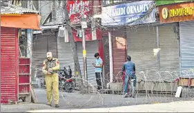  ?? PTI ?? A security personnel blocks a road during restrictio­ns in Srinagar on Thursday.