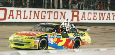  ?? AP PHOTO/BRETT FLASHNICK ?? NASCAR Cup Series driver Mark Martin waves the checkered flag after winning the Southern 500 on May 9, 2009, at Darlington Raceway in South Carolina. The ventue known as “The Lady in Black” and “The Track Too Tough to Tame” has a rich history.