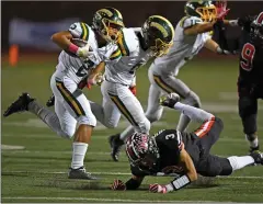  ?? Jayne Kamin-Oncea/For The Signal ?? Canyon’s James Mendibles, left, gains 7 yards after he is tripped by Hart’s Jacob Montes in the first half of the game.