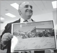  ?? DON Healy/leader-post ?? Jose Henriquez holds an autographe­d photo of Thyssen Mining Constructi­on of Canada Ltd., employees wishing him well.