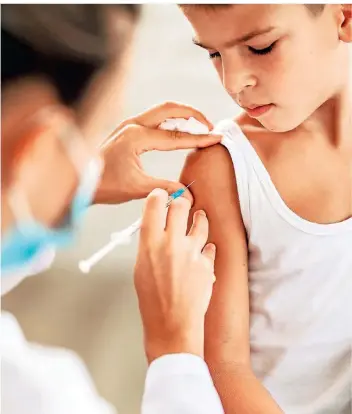  ?? FOTO:ISTOCK ?? Ein Arzt impft einen Jungen. Politiker streiten, ob sich Eltern an die Empfehlung­en der Stiko für eine Impfung ihrer Kinder gegen Corona halten sollten oder nicht.