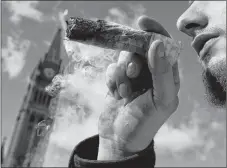  ?? CP PHOTO ?? A man smokes a marijuana joint during the annual 4/20 marijuana celebratio­n on Parliament Hill in Ottawa on April 20.