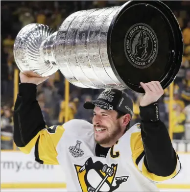  ?? The Associated Press ?? Pittsburgh Penguins' Sidney Crosby celebrates with the Stanley Cup after defeating the Nashville Predators in Game 6 of the NHL hockey Stanley Cup Final on Sunday in Nashville,Tenn.