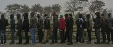  ?? MAURICIO LIMA/THE NEW YORK TIMES ?? Refugees wait to be registered after eviction from their tents. Several dwellings were set on fire by migrants in protest.