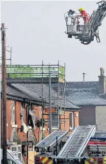  ??  ?? Police forensics team study chimney of family home