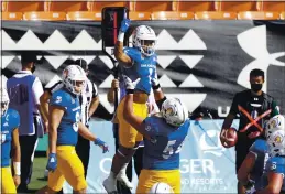  ?? MARCO GARCIA – THE ASSOCIATED PRESS ?? San Jose State offensive lineman Jaime Navarro (54) holds up wide receiver Isaiah Holiness (1) after Holiness made a touchdown against Hawaii in the first half on Saturday.