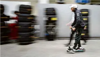  ??  ?? Pentacampe­ão, Lewis Hamilton anda de patinete pelo paddock do autódromo