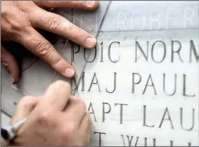  ?? Special to the Arkansas Democrat-Gazette ?? A contractor works April 21 adding names to the High Flight Memorial at Little Rock Air Force Base in Jacksonvil­le.