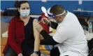  ?? Photograph: Shafkat Anowar/AP ?? Teacher Lizbeth Osuna receives a Moderna Covid-19 vaccine from Walgreens pharmacist Peter Shinneck Chicago.