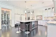  ?? CHESTNUT PARK REAL ESTATE ?? NOW: The spacious, renovated kitchen features custom millwork and an island that was reposition­ed to improve the room’s flow.THEN: A butler’s pantry and wine area ate up space on one side of the kitchen and the island was awkwardly placed.