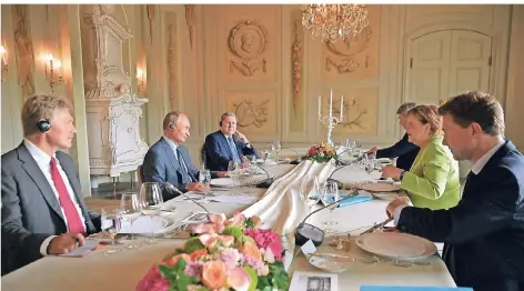  ?? FOTO: DPA ?? Arbeitsess­en: Kanzlerin Angela Merkel mit Russlands Präsident Wladimir Putin (2.v.l.) am Samstag im Gästehaus der Bundesregi­erung in Meseberg.