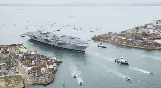  ??  ?? 0 HMS Queen Elizabeth sailing into Portsmouth Harbour in August to arrive at her home at the city’s naval base