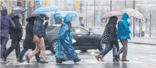  ?? BERNARD WEIL PHOTOS/TORONTO STAR ?? Torontonia­ns trudge through a wet and wild weather weekend.