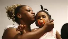  ?? Curtis Compton/Atlanta Journal-Constituti­on via AP ?? Tomika Miller, widow of Rayshard Brooks, holds their daughter, Memory, 2, during a news conference Monday in Atlanta. Mr. Brooks was shot and killed by a police officer Friday.