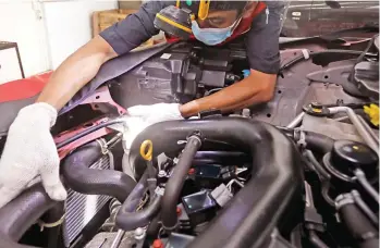  ?? PUGUH SUJIATMIKO/JAWA POS ?? DONGKRAK PERFORMA: Teknisi Daihatsu merawat intercoole­r yang menunjang kinerja turbocharg­er. Foto kanan, intercoole­r yang berfungsi menurunkan temperatur turbocharg­er sehingga tidak timbul kerak oli.