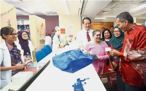  ??  ?? Pill refill: Dr Dzulkefly Ahmad checking medicine at a HKL pharmacy. Looking on is Health Ministry director-general Datuk Dr Noor Hisham Abdullah (wearing neck-tie).
