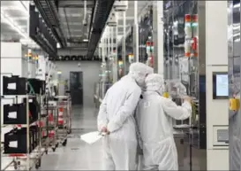  ?? LUO XIAOGUANG / XINHUA ?? Technician­s of Semiconduc­tor Manufactur­ing Internatio­nal Corp inspect the company’s facilities in Beijing.