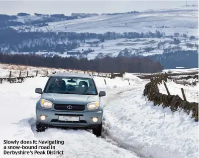  ?? ?? Slowly does it: Navigating a snow-bound road in Derbyshire’s Peak District