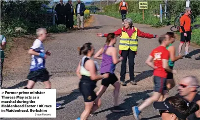  ?? Steve Parsons ?? Former prime minister Theresa May acts as a marshal during the Maidenhead Easter 10K race in Maidenhead, Berkshire