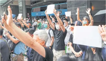  ??  ?? PAPER PROTEST: Supporters raise white paper to avoid slogans banned under the national security law in Hong Kong.