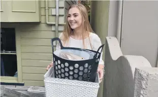  ?? PHOTO: GREGOR RICHARDSON ?? Moving on . . . Student Chloe Hedges (20) carries her belongings to a removal truck yesterday morning.