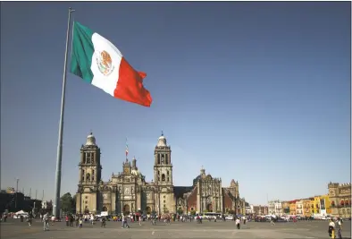  ?? Getty Images ?? Mexico City cathedral framed under the huge flag, at the Zocalo square. The flag is lowered at sunset each evening, and raised at 8 every morning.
