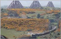  ?? PICTURE: REUTERS ?? The Forth Bridge dominates the background as the Flying Scotsman train travels through the Fife countrysid­e, during a tourist trip to the Scottish region and a visit to Edinburgh at the weekend.