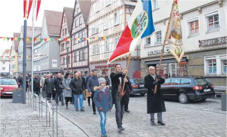  ?? FOTO: VERA ROMEU FOTO: ?? Mit ihrer Zunftlade und Fahnen ziehen die Mengener Handwerker die Hauptstraß­e hinauf.