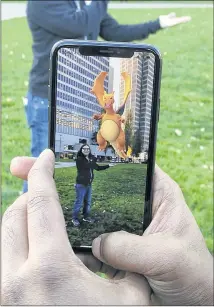  ?? MICHAEL LIEDTKE / ASSOCIATED PRESS ?? A “Pokemon Go” player approaches a Pokemon at a park in San Francisco, Calif. An upcoming game update will integrate Apple’s new augmented reality software, ARKit, offering new features to players using newer-model iPhones.