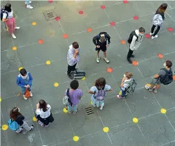  ??  ?? Bolli colorati Così il liceo artistico statale Giacomo e Pio Manzù di Bergamo prova a garantire il distanziam­ento sociale tra gli studenti nel cortile dell’edificio scolastico di via Tasso