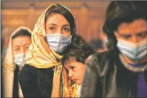  ?? (AP/Vadim Ghirda) ?? A woman of the Armenian community in Romania holds a young child during the Easter religious service.