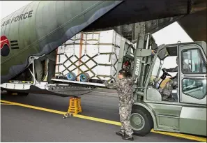  ?? — AFP ?? Tangerine peace dream: A South Korean military transport aircraft being loaded with tangerines bound for North Korea at Jeju island.