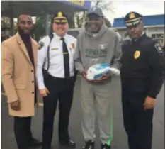  ?? COLIN AINSWORTH - DIGITAL FIRST MEDIA ?? Joe “Blinky” Harvey holds his turkey at the 22nd Street and Edgmont Avenue Sunoco station, joined by Councilman William Morgan, Major Steven Gretsky and Commission­er Otis Blair.