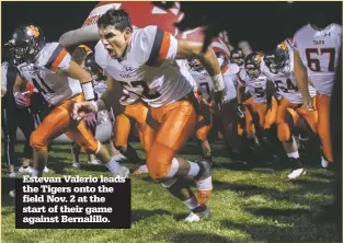  ??  ?? Estevan Valerio leads the Tigers onto the field Nov. 2 at the start of their game against Bernalillo.