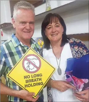  ??  ?? Tony and Judy Fisher hold warning signs about breath holding in the hope of spreading word that Shallow Water Blackout can be prevented with awareness. Their son Nic, aged 12, died in 2001 of SWB. PHOTO: DUBBO PHOTO NEWS