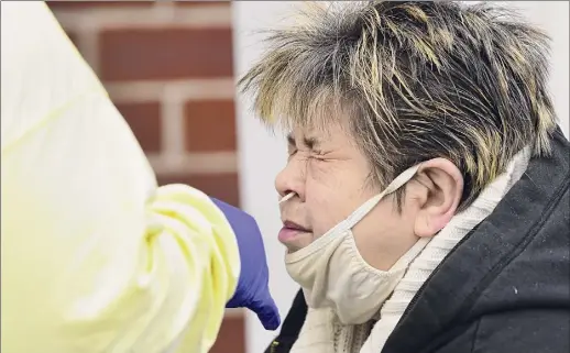  ?? Photos by Lori Van Buren / Times Union ?? Sarah Hunt of Watervliet winces as she gets tested at the drive-through COVID-19 testing site at the Whitney Young Administra­tive Building on Wednesday in Watervliet.