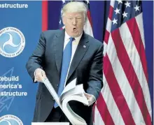  ?? ANDREW HARNIK/THE ASSOCIATED PRESS ?? U.S. President Donald Trump shows the size of road planning documents for a highway plan in Maryland on Friday. Trump took to Twitter Friday morning to weigh in on fired FBI director James Comey’s testimony on Thursday.