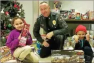  ?? CITY OF COATESVILL­E POLICE DEPARTMENT FACEBOOK PHOTO ?? Members of the Coatesvill­e Police Department issued “tickets” to youths in Coatesvill­e for “doing something right.” The tickets are holiday shopper dollars for the kids to purchase gifts for their family members. Sgt. Rodger Ollis poses with two...