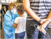  ?? EDUARDO CONTRERAS U-T ?? COVID tester Anney Luquin (left) performs a COVID test at the Chula Vista Elementary School District Education Service and Support Center on Thursday.