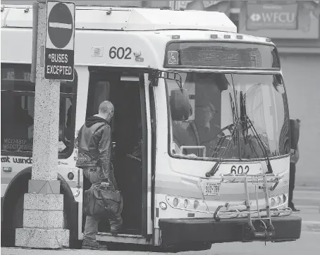  ?? DAN JANISSE ?? A Transit Windsor bus driver picks up a passenger in the city’s downtown area. Transit officials plan to hire 16 new drivers.