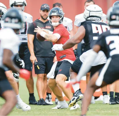  ?? ALEX SLITZ/AP ?? Atlanta Falcons quarterbac­k Taylor Heinicke, center, looks to pass during training camp on July 29 in Flowery Branch, Georgia.