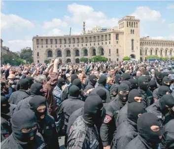  ?? — AFP ?? Policemen wearing hoods gather during a demonstrat­ion called by opposition in central Yerevan on Sunday, held to protest former president’s election as prime minister.