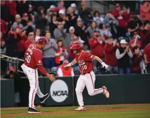  ?? NWA Democrat-Gazette/Andy Shupe ?? Arkansas first baseman Peyton Stovall (10) is congratula­ted by assistant coach Nate Thompson after hitting a two-run home run during the second inning of Saturday’s game against Kentucky at Baum-Walker Stadium in Fayettevil­le.