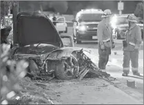  ??  ?? Sheriff’s deputies work near the wreckage of a Porsche that crashed into a light pole Nov. 30 on Hercules Street near Kelly Johnson Parkway in Valencia, Calif. Actor Paul Walker, the star of the “Fast & Furious” movie series, seen at left, and racing...
