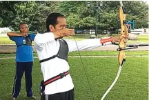  ?? RIZAL BANARDI FOR JAWA POS ?? KONSENTRAS­I: Rizal Banardi saat melatih panahan Presiden Joko Widodo di Istana Bogor. Foto kanan, Rizal memeriksa anak panah Jokowi.